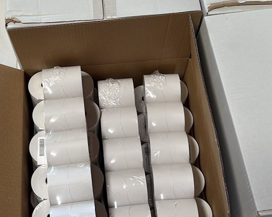 Offener Karton mit 50 weißen Bonrollen, original verpackt